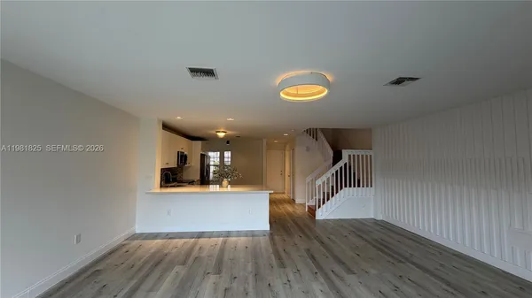 a view of a livingroom with wooden floor and a ceiling fan