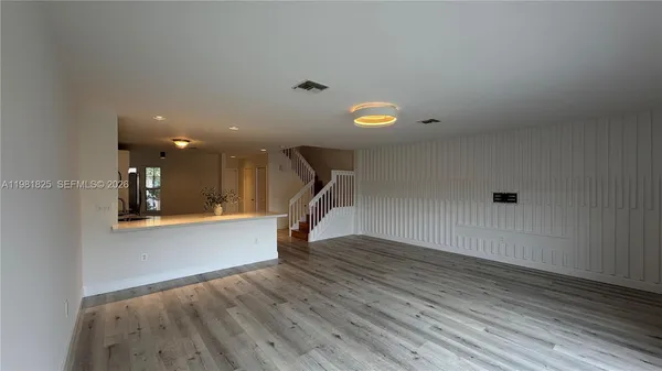 a view of a livingroom with wooden floor and staircase