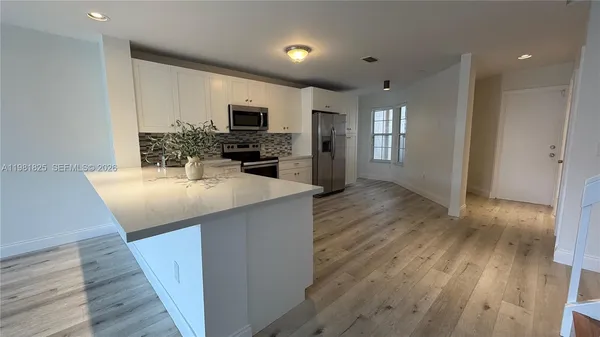 a kitchen with stainless steel appliances kitchen island granite countertop a sink refrigerator and microwave