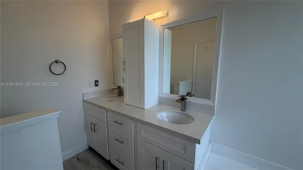a bathroom with a double vanity sink and a mirror