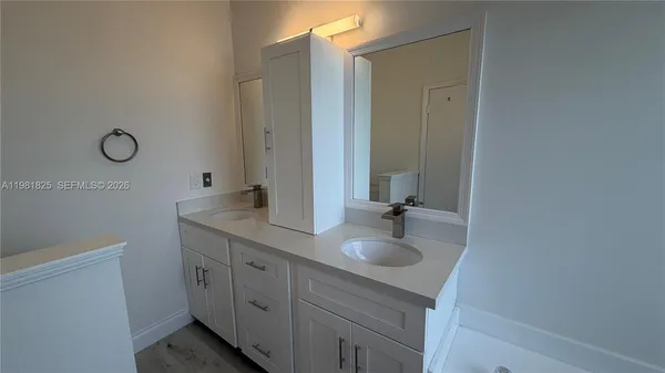 a bathroom with a double vanity sink and a mirror