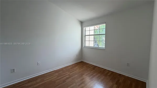 a view of a room with wooden floor and windows in it