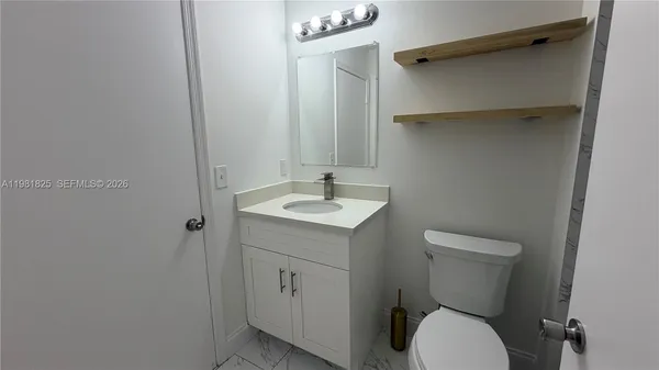 a bathroom with a toilet a sink and mirror