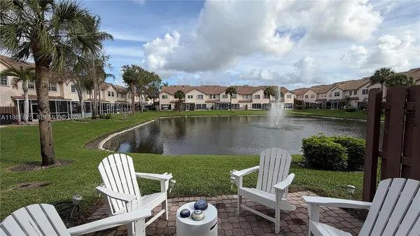 a view of a lake with a garden and outdoor seating