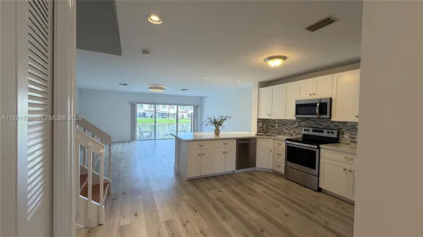 a large kitchen with a lot of counter space and stainless steel appliances