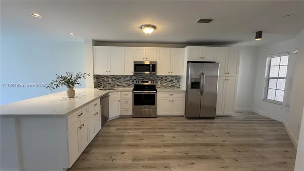 a large kitchen with a stove top oven a sink and dishwasher
