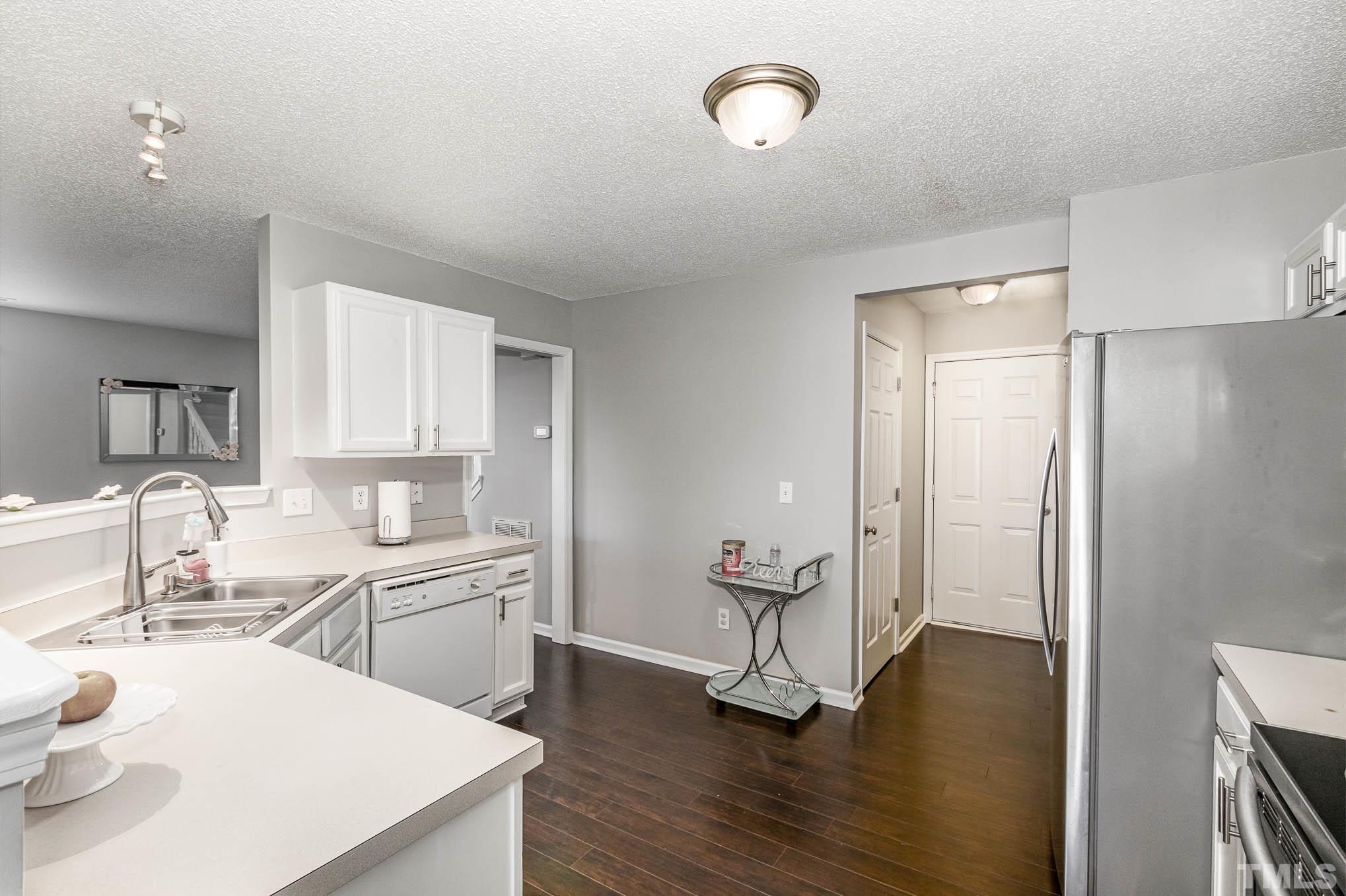 266 Inkster Cove Raleigh, NC 27603 - Photo 12 of 30 a kitchen with a sink a refrigerator and wooden floor