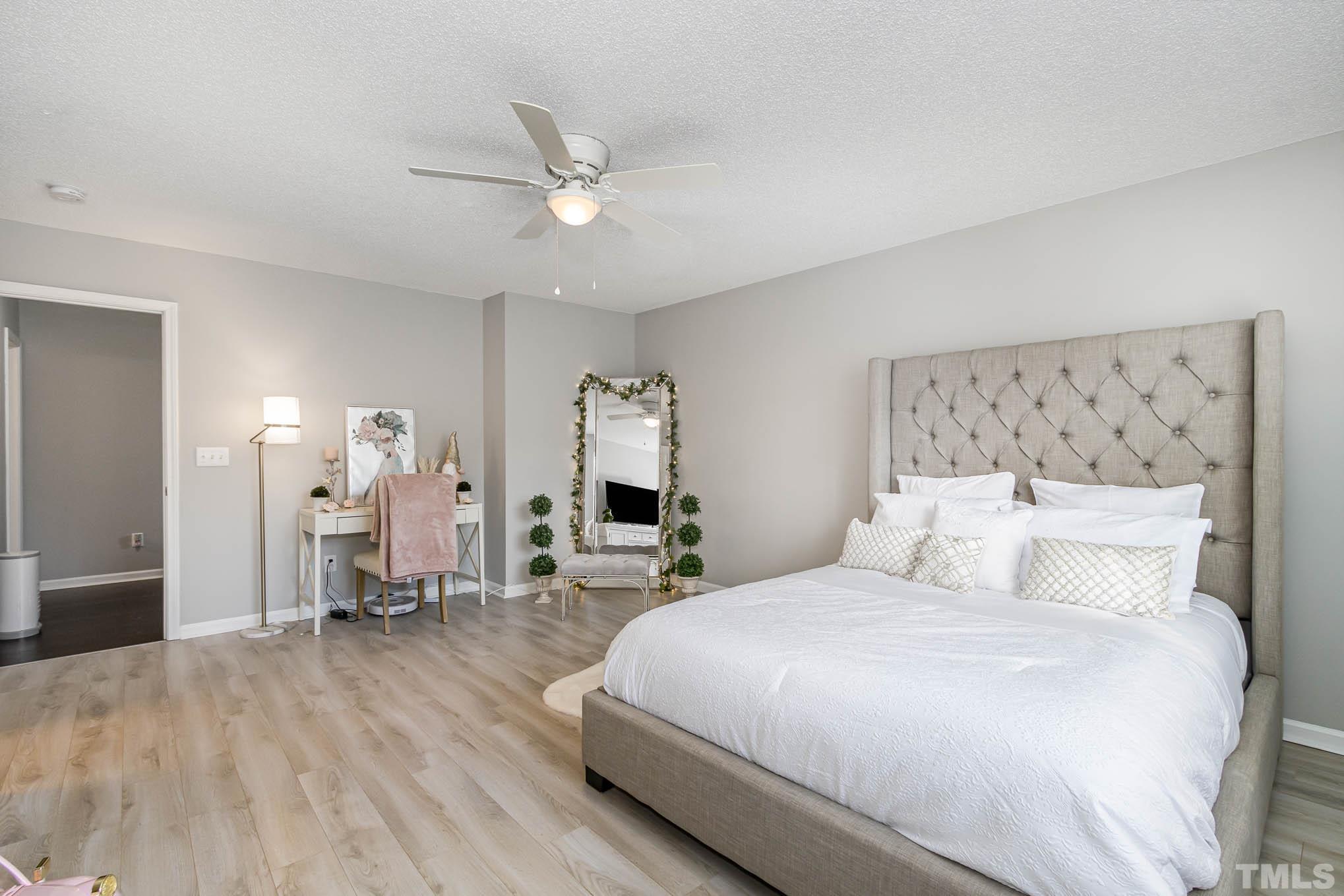 266 Inkster Cove Raleigh, NC 27603 - Photo 18 of 30 a bedroom with a large bed and a chandelier