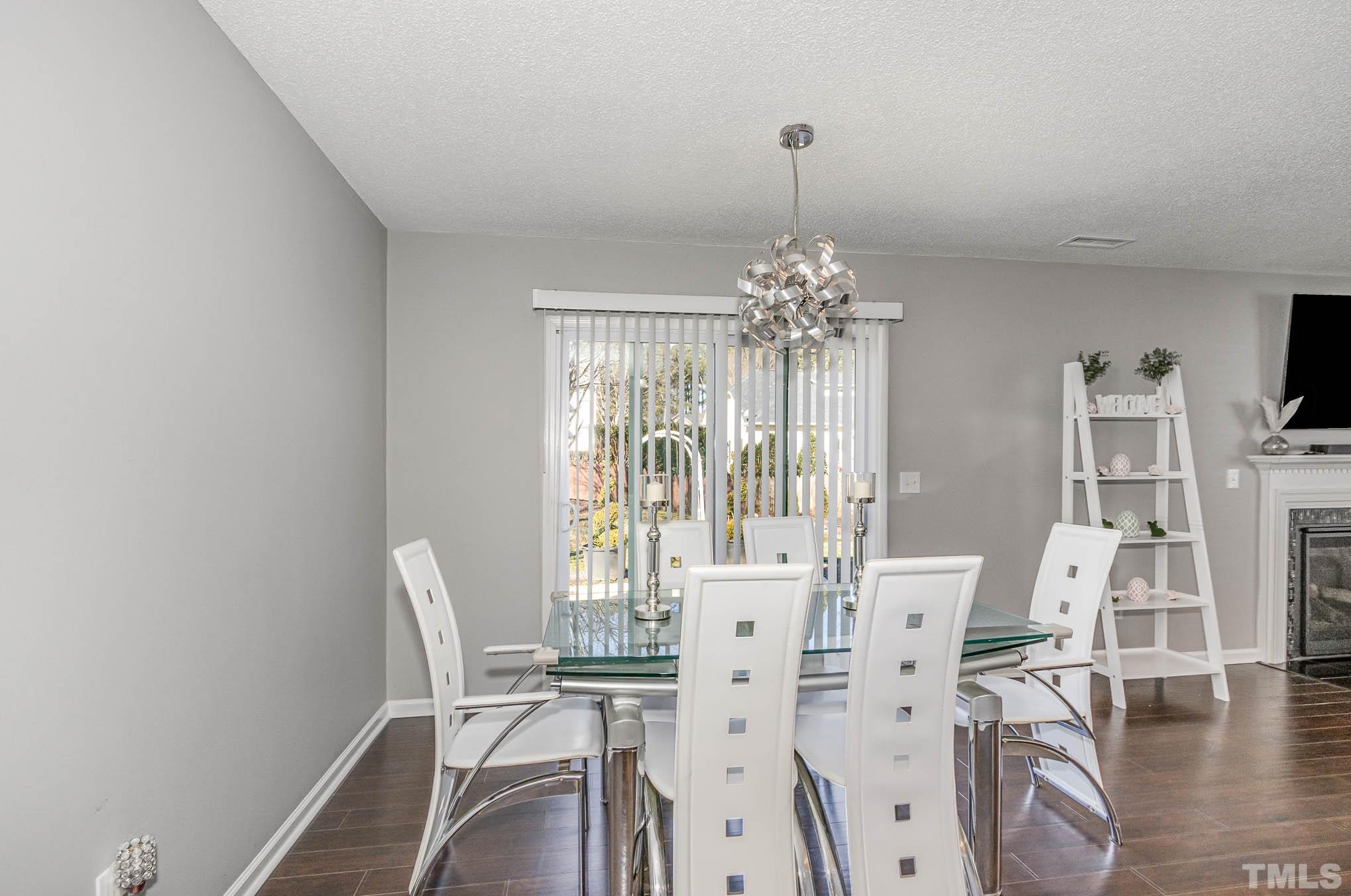 266 Inkster Cove Raleigh, NC 27603 - Photo 8 of 30 a view of a dining room with furniture wooden floor and chandelier