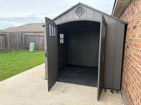 a view of kitchen with stainless steel appliances granite countertop a stove top oven a sink dishwasher and a refrigerator with wooden floor