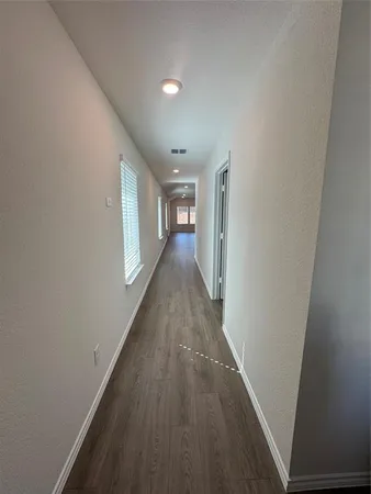 a view of a hallway with wooden floor