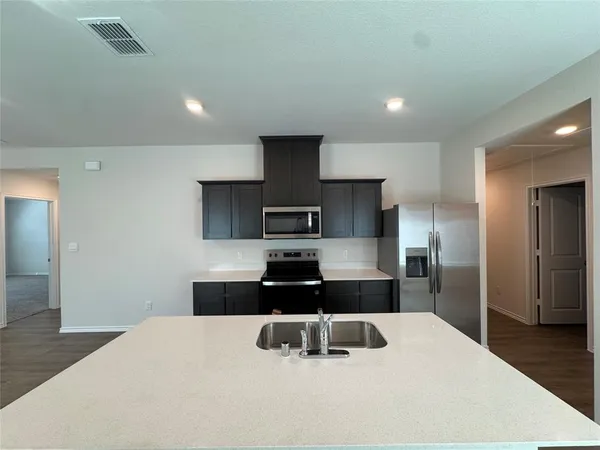 a kitchen with stainless steel appliances kitchen island sink refrigerator and stove