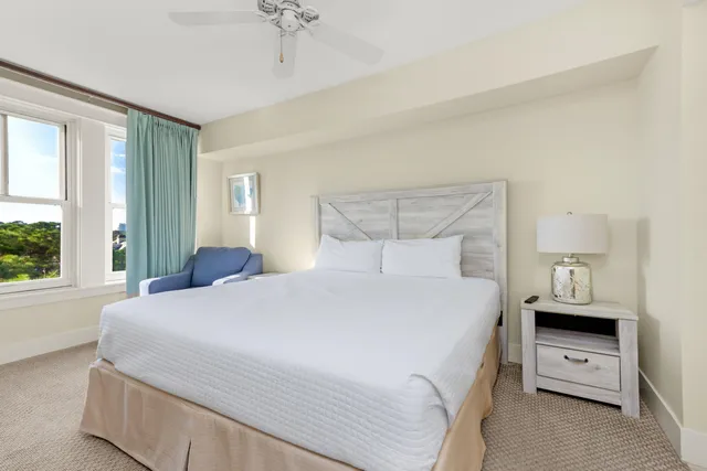 a bedroom with a large bed and a chandelier