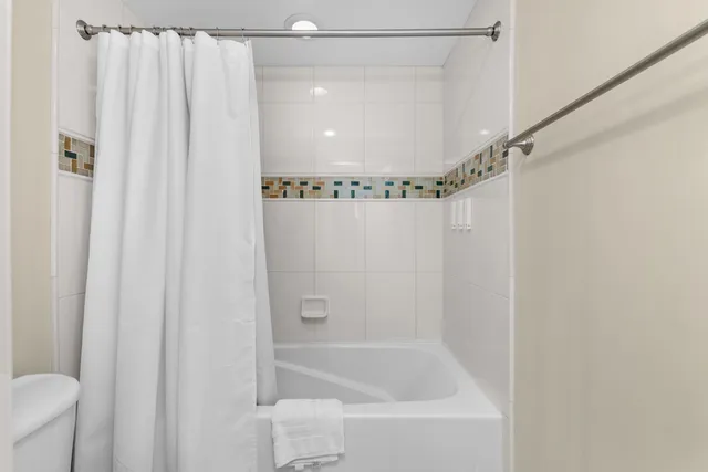 a kitchen with a refrigerator a stove top oven and white walls