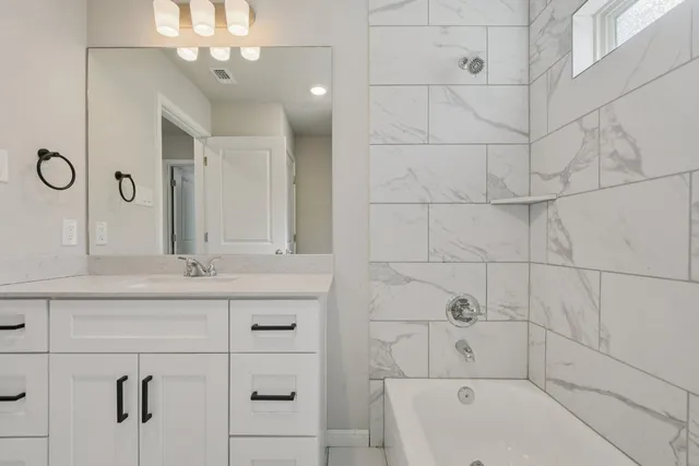 a bathroom with a sink mirror toilet and bathtub