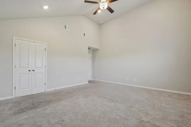 an empty room with a ceiling fan and a window