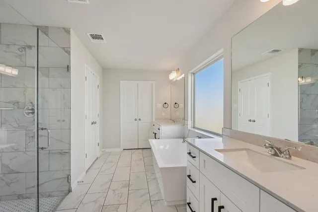 a spacious bathroom with a shower sink and mirror