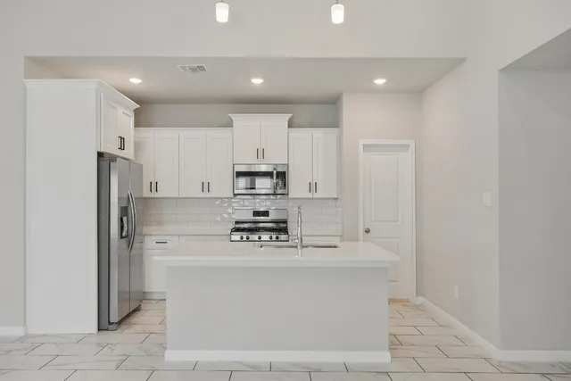 a kitchen with cabinets stainless steel appliances and a counter space