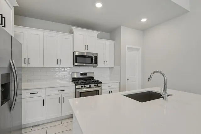 a kitchen with stainless steel appliances a refrigerator sink and stove