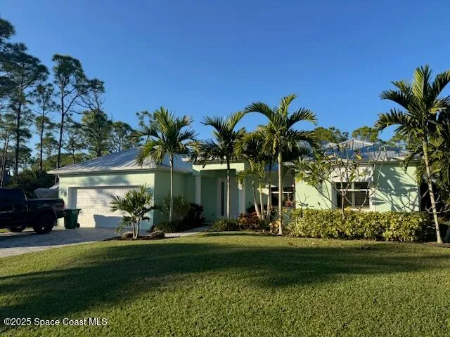 an aerial view of a house with a yard swimming pool and large trees