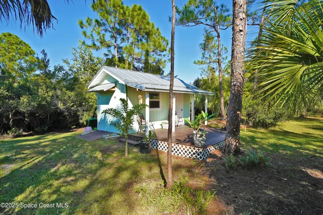 a view of backyard with table and chairs and wooden fence
