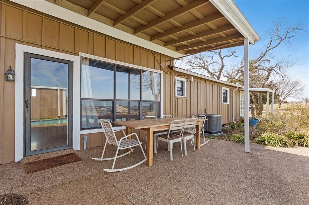 9213 Wilson Road Pilot Point, TX 76258 - Photo 27 of 36 Expansive outdoor patio featuring a concrete surface, a covered overhang, and a glass-paneled entry door