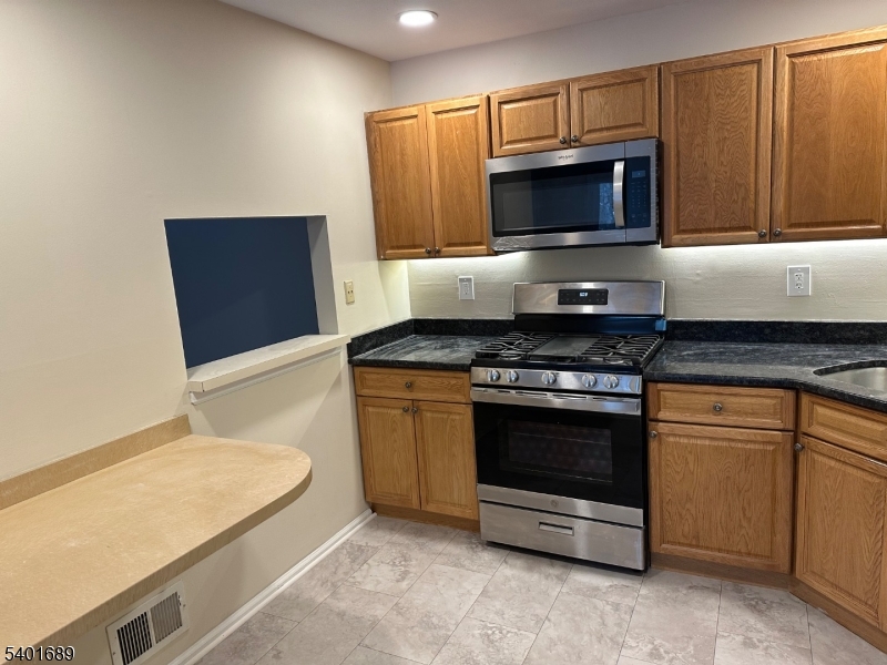 236 Irving Place Basking Ridge, NJ 07920 - Photo 7 of 18 a kitchen with granite countertop a stove and a microwave