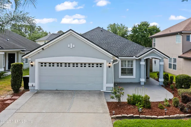 a view of a house with a yard and potted plants