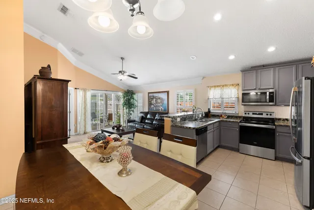 a large kitchen with kitchen island granite countertop a large counter top stainless steel appliances and cabinets