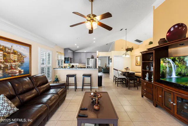 a living room with furniture a flat screen tv and a large window