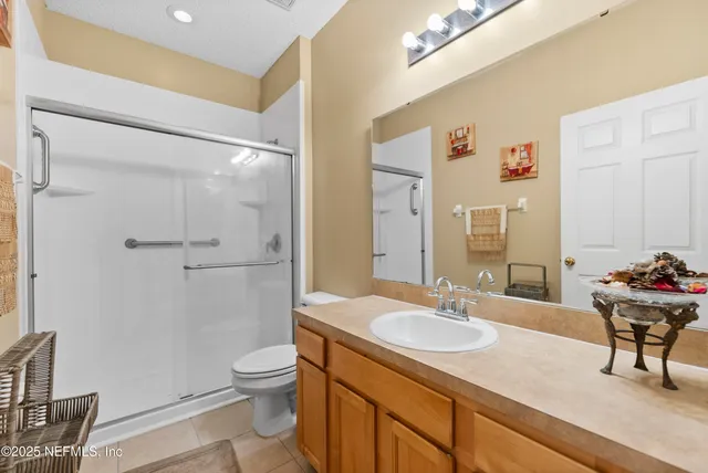 a bathroom with a granite countertop sink toilet a mirror and shower
