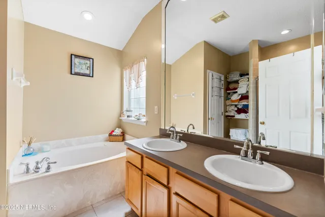 a bathroom with a granite countertop sink and a large mirror