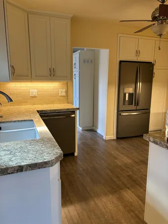 a kitchen with granite countertop a refrigerator and a sink