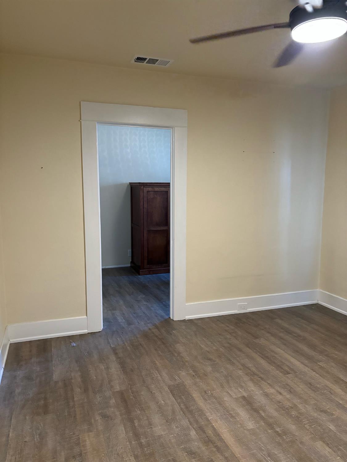 417 Enslen Avenue Modesto, CA 95354 - Photo 14 of 24 a view of an empty room with wooden floor and a window