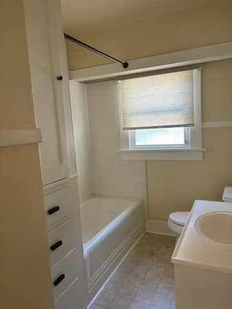 a bathroom with a bathtub a window and a shower