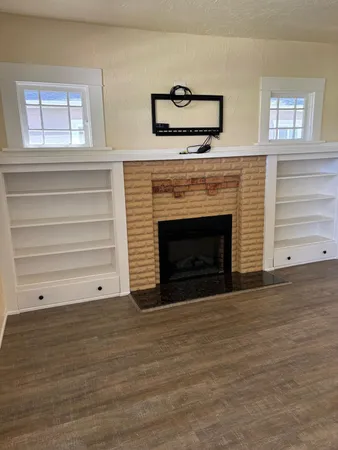 a view of an empty room with a fireplace and a window