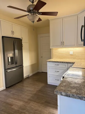 a kitchen with stainless steel appliances granite countertop a refrigerator and a stove