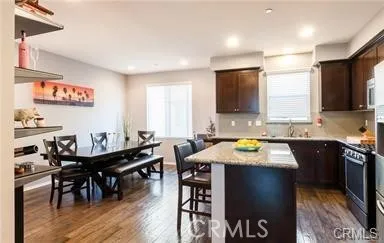 a kitchen with a dining table chairs and white appliances