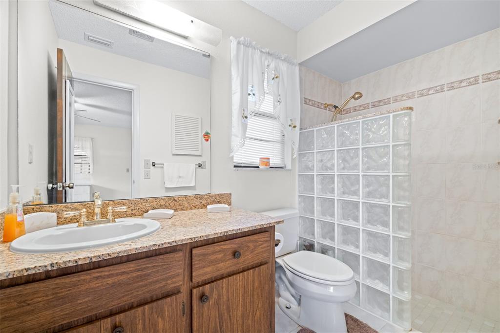 623 Racoon Lane Lorida, FL 33857 - Photo 24 of 80 a bathroom with a granite countertop sink a toilet a mirror and shower