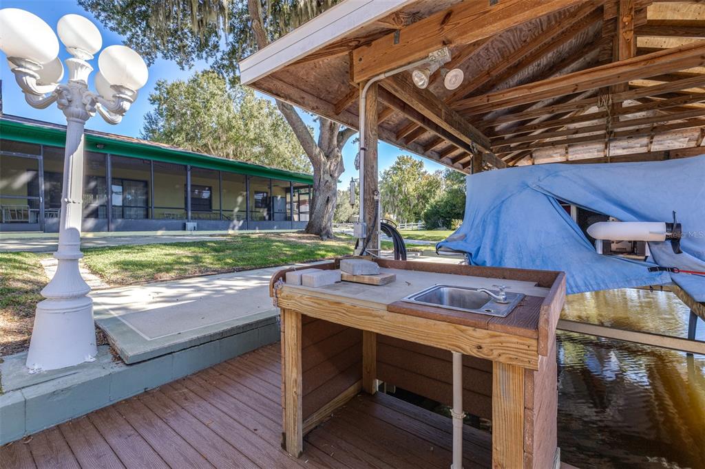623 Racoon Lane Lorida, FL 33857 - Photo 47 of 80 a view of a patio with table and chairs with wooden floor and fence