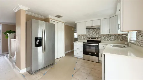 a kitchen with a stove sink and refrigerator