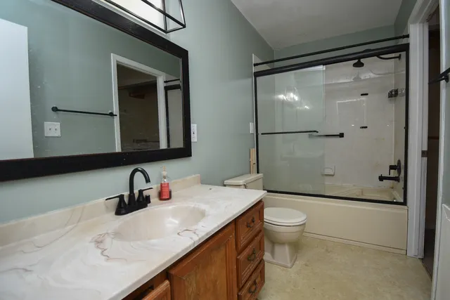 a bathroom with a granite countertop sink toilet and shower