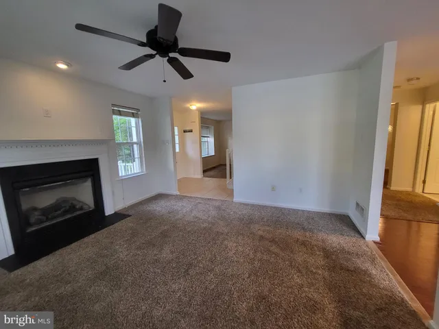 a view of an empty room with a fireplace and a window