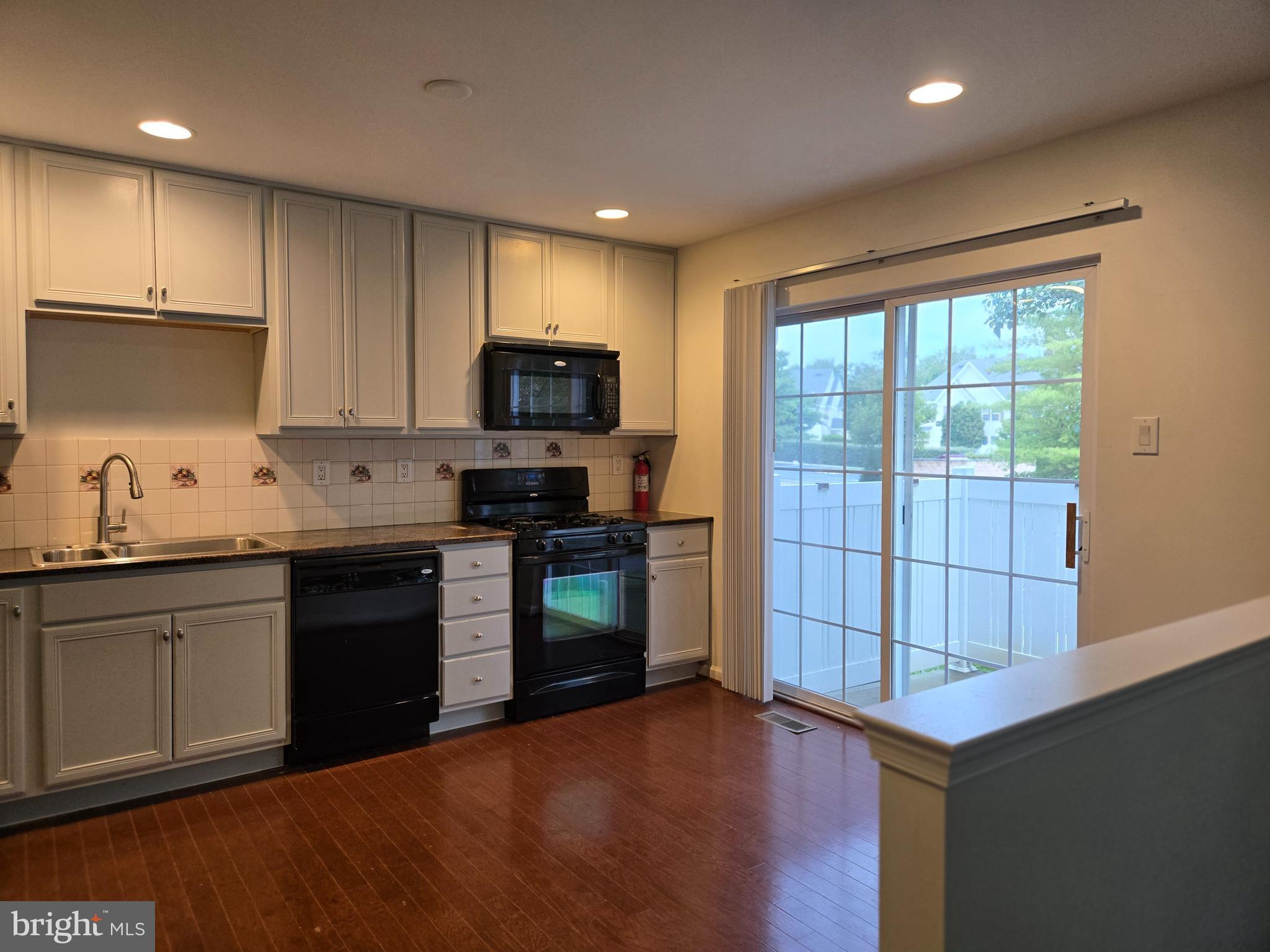284 Flagstone Road, Unit 5 Chester Springs, PA 19425 - Photo 9 of 25 a kitchen with kitchen island granite countertop a stove top oven a sink dishwasher a refrigerator and cabinets with wooden floor