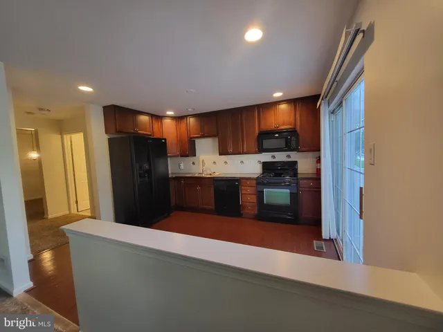 a kitchen with stainless steel appliances kitchen island granite countertop a refrigerator a oven a sink with a dining table and chairs