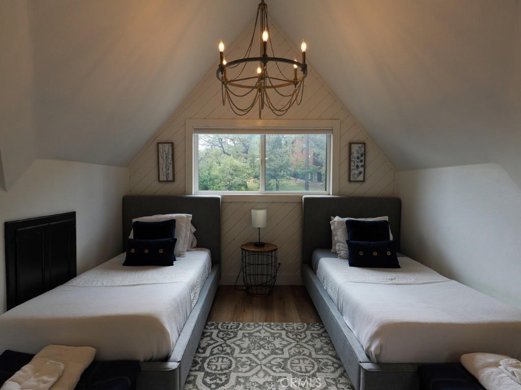 28596 North Bay Road Lake Arrowhead, CA 92352 - Photo 39 of 69 a bedroom with a bed and a chandelier