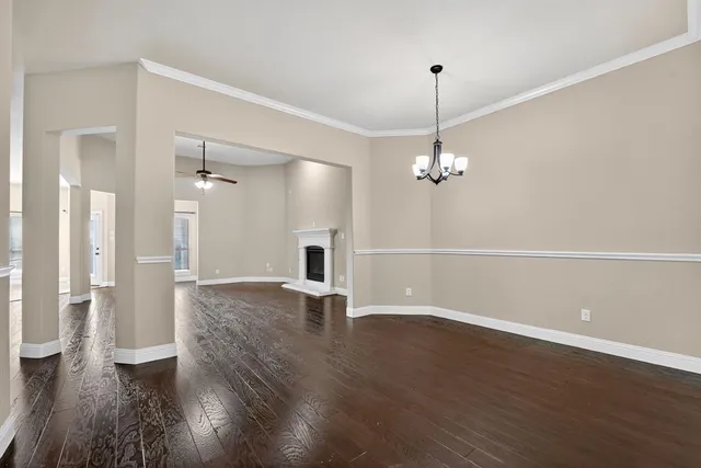 a view of a livingroom with wooden floor and a ceiling fan