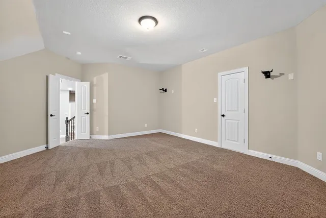 an empty room with a ceiling fan and windows