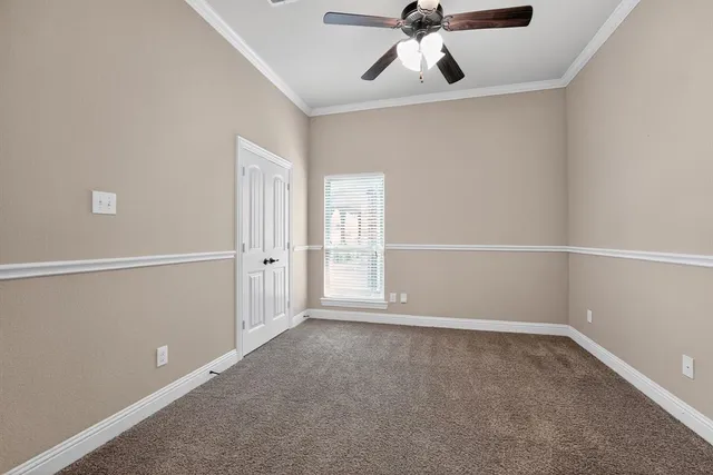 an empty room with wooden floor closet and windows