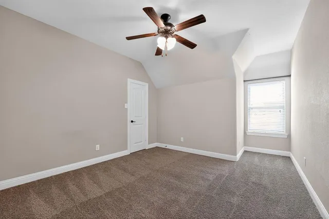 an empty room with a window and a ceiling fan